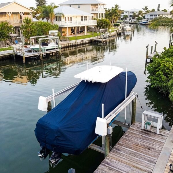 EdgeWater 200 T-Top boat cover in navy Sunbrella fabric on dock lift at Ponce Inlet Florida canal