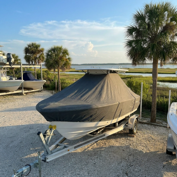 EdgeWater 208 T-Top boat cover in charcoal Sunbrella fabric on dock lift at Mosquito Lagoon Florida