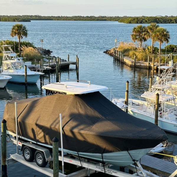 Everglades 235 CC T-Top boat cover in Charcoal Sunbrella fabric on dock lift at Sebastian Inlet, FL marina