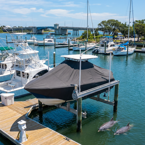 Sailfish 220 T-Top boat cover in charcoal Sunbrella fabric on dock lift at Wrightsville Beach North Carolina