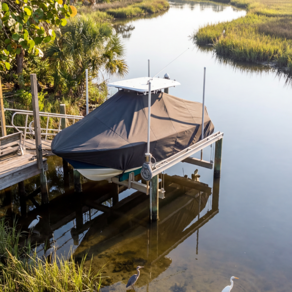 Sea Pro 245 FLX T-Top boat cover in Charcoal Sunbrella fabric on dock lift at Amelia Island, FL