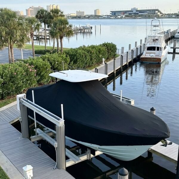 Pathfinder 2600 TRS T-Top boat cover in Black Sunbrella fabric on dock lift at Daytona Beach, Florida