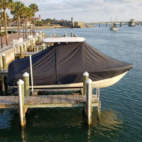 Pathfinder 2700 T-Top boat cover in Charcoal Sunbrella fabric on dock lift at St. Augustine, Florida