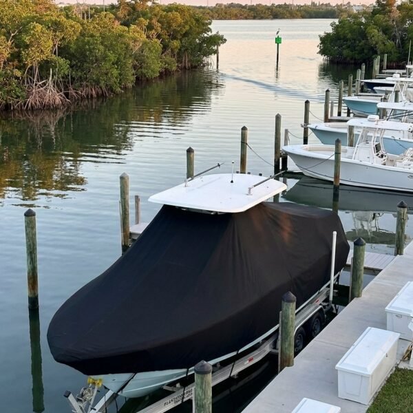 Pursuit 180 C T-Top boat cover in Black Sunbrella fabric on dock lift at Fort Pierce, Florida