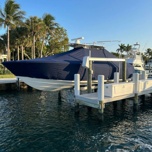 Pursuit 230 C T-Top boat cover in Navy Sunbrella fabric on dock lift at Sebastian Inlet, Florida
