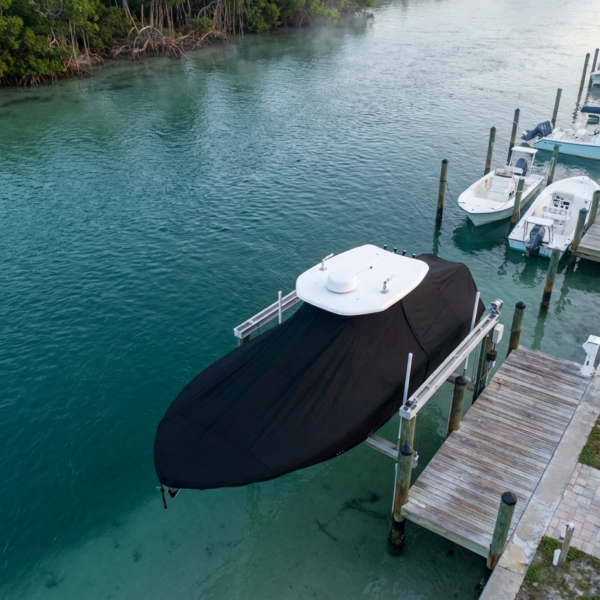 Pursuit 238 C T-Top boat cover in Black Sunbrella fabric on dock lift at Stuart, Florida