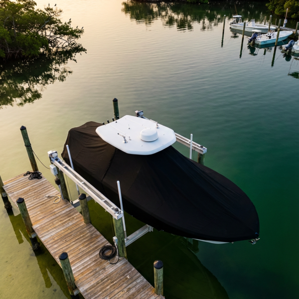 Pursuit 265 DC T-Top boat cover in Black Sunbrella fabric on dock lift at St. Lucie Inlet, Florida