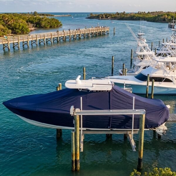 Pursuit 3070 Offshore T-Top boat cover in Navy Sunbrella fabric on dock lift at Sebastian Inlet, Florida