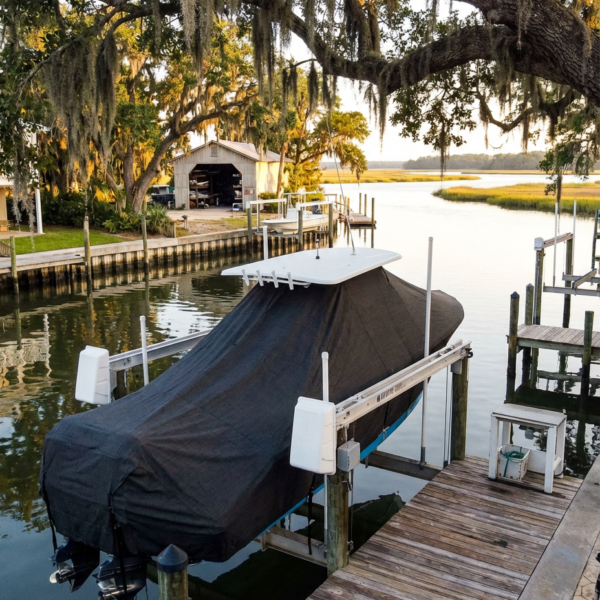 Sea Fox 248 Side Console T-Top boat cover in Charcoal Sunbrella fabric on canal lift at Isle of Hope Marina, Isle of Hope, GA