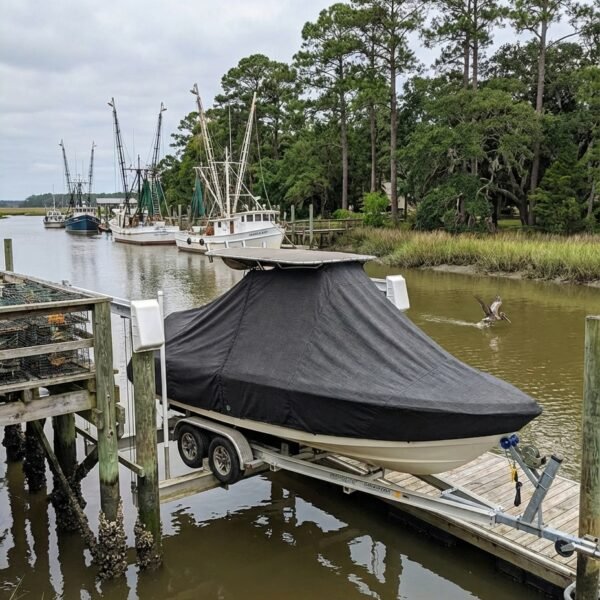 Tidewater 2210 Carolina Bay T-Top boat cover in Charcoal Sunbrella fabric on dock lift