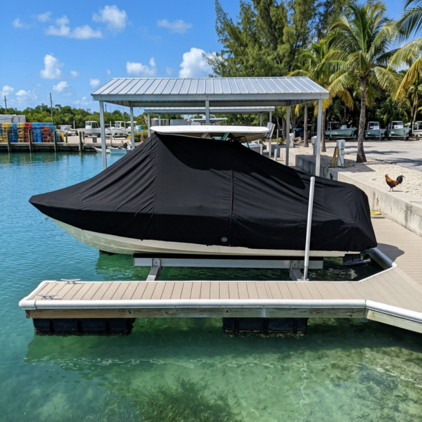 Covered motorboat on a lift at a sunny marina, turquoise water, and palm trees in the background.