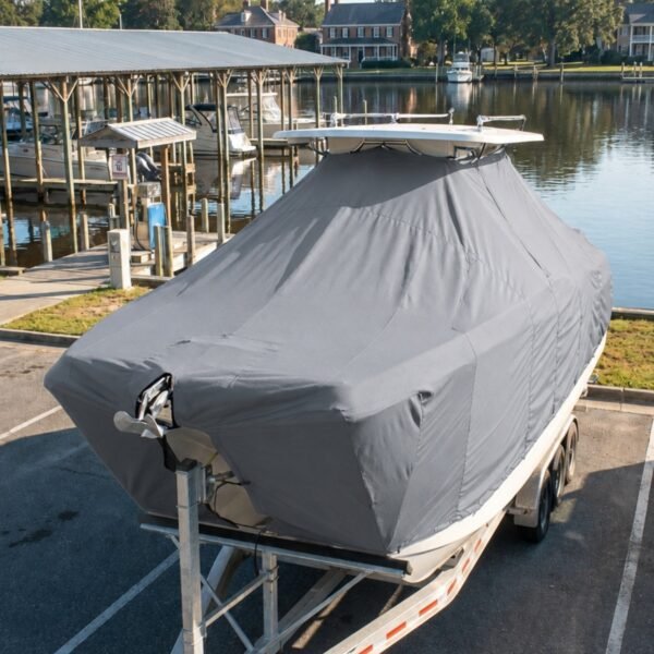 Twin Vee 280 GFX2 T-Top boat cover in Smoke grey Sunbrella fabric with bow anchor cutout, on trailer at a waterfront marina